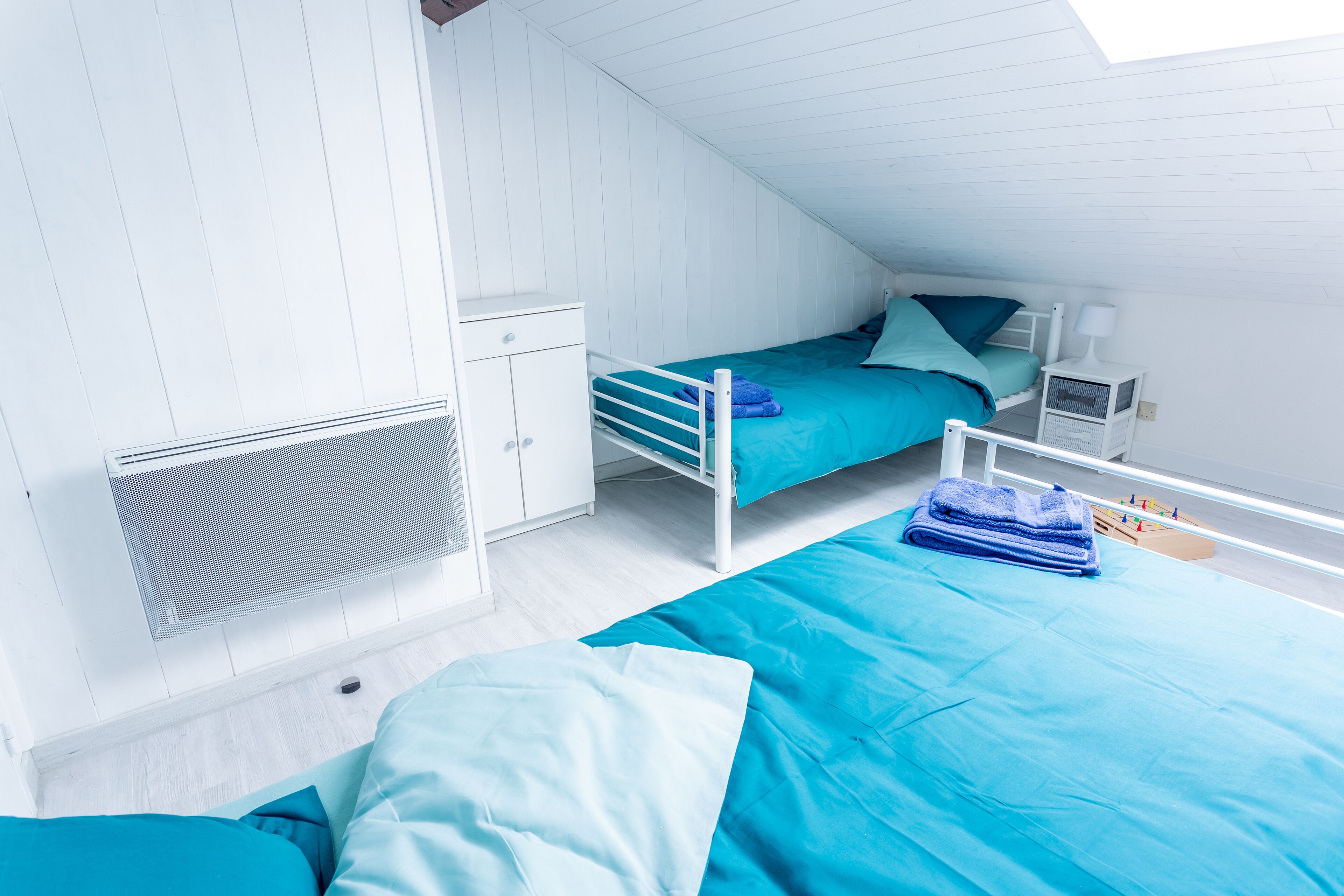 Ein Schlafsaalzimmer mit Etagenbetten, einem Schreibtisch, einem Stuhl und einem Fenster.