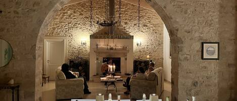 Un comedor con un arco de piedra, una chimenea y una mesa dispuesta para comer.