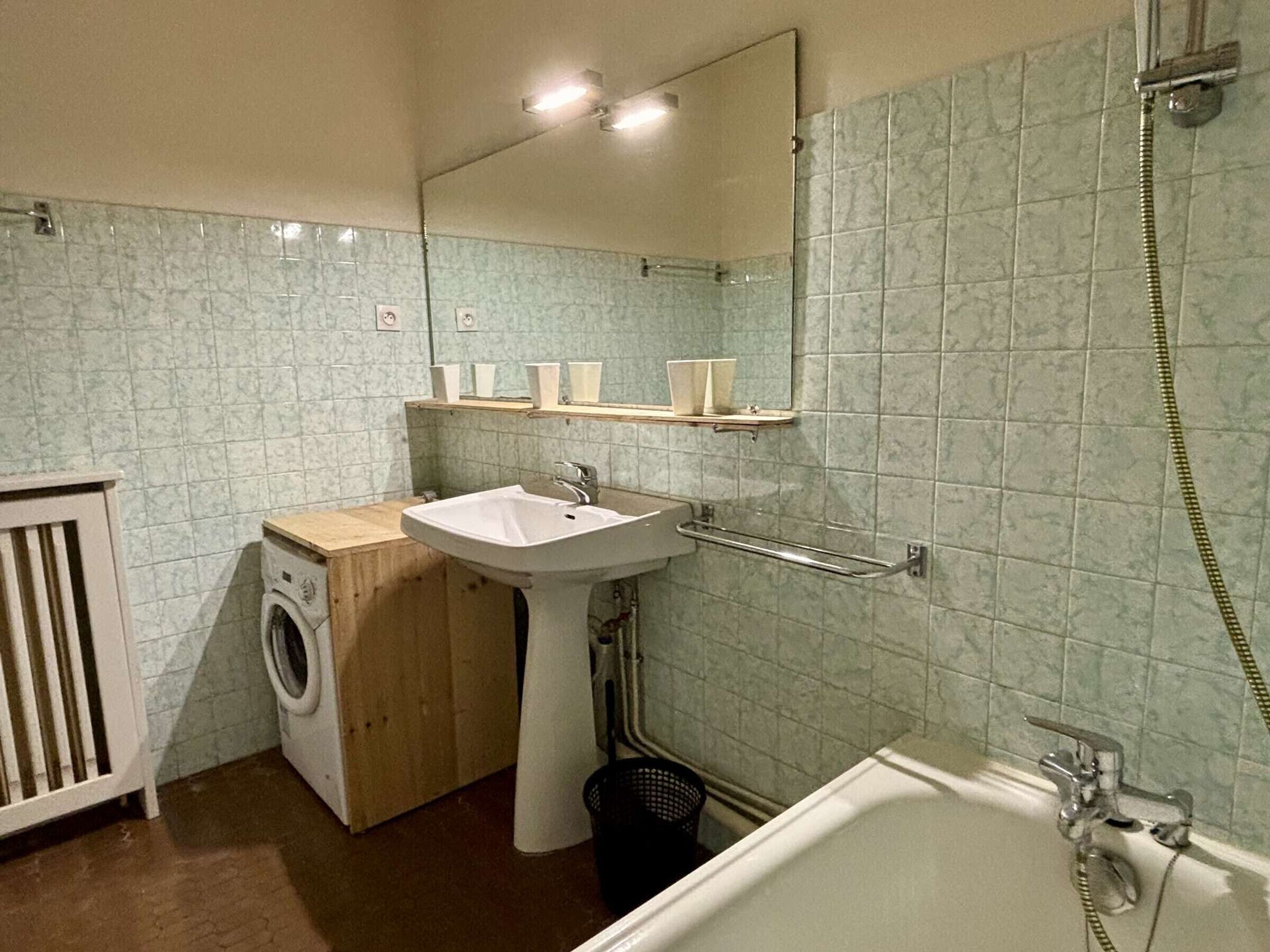 A bathroom with a sink, mirror, and shower.