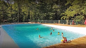 A swimming pool surrounded by trees, with people swimming and sitting on the deck. - --- Mobile home n ° 17 --- (ESCARO)