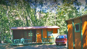 A small cabin with a porch and a car parked in front. - --- Mobile home n ° 17 --- (ESCARO)