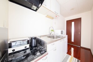 A kitchen with a microwave, toaster, and sink.