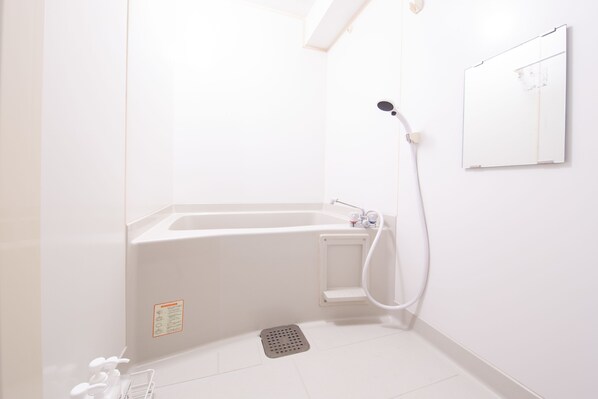 A modern bathroom with a bathtub, shower, and a small sink.