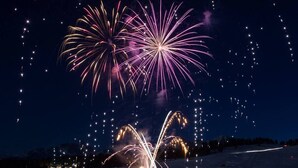 A snowy landscape with fireworks in the sky.