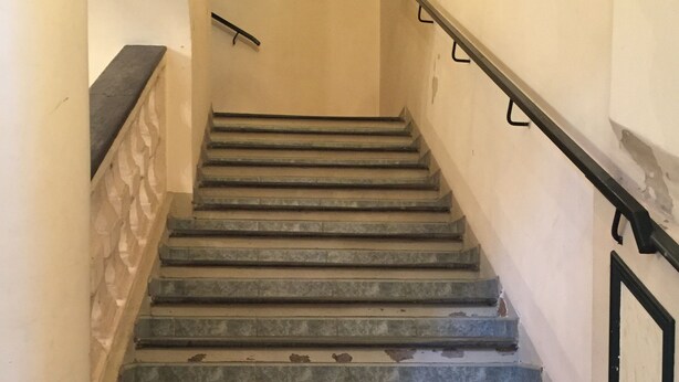 A staircase with stone steps and black handrails, leading to a landing with a small shelf. - Studio old town 17m2, 1min from the sea (Menton)