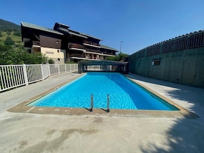 A rectangular swimming pool with a diving board in the center, surrounded by a concrete deck. - Cozy Duplex with Pool, Sleeps 4-5, Central Arêches-Beaufort, 50m from Shops and Slopes (Arêches-Beaufort)
