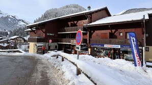 Un bâtiment recouvert de neige, sur lequel se trouve un restaurant appelé « Au Bon » et une enseigne indiquant « Val Blanc ».