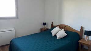 A bedroom with a single bed, two bedside tables, a window, and a radiator. - Spacious Apt for 6 with Balcony in Peyragudes, 500m from Slopes, Free Spa Access (Peyragudes)