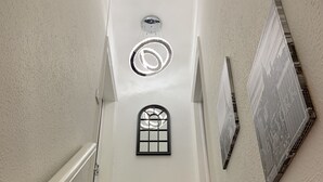 A staircase with carpeted steps, a wall-mounted picture frame, and a small window with a grid pattern. - GuywoodHouse (Stockport)
