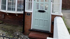 A house with a light blue door, numbered 10, and a small porch area. - GuywoodHouse (Stockport)