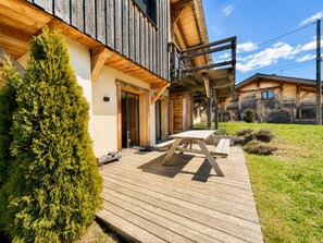 A wooden cabin with a deck, a door, and a small garden. - Charming apartment with large terrace and parking (Notre-Dame-de-Bellecombe)