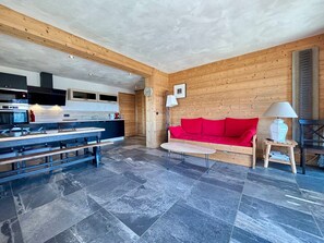 Moderni keittiö, jossa on ruokailutila, punainen sohva ja lamppu.