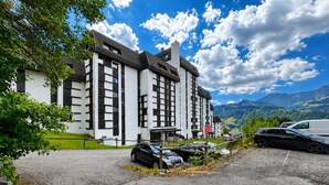 A large building with multiple windows and a parking area in front. - Ski-in studio with balcony views in Notre-Dame-de-Bellecombe (Notre-Dame-de-Bellecombe)