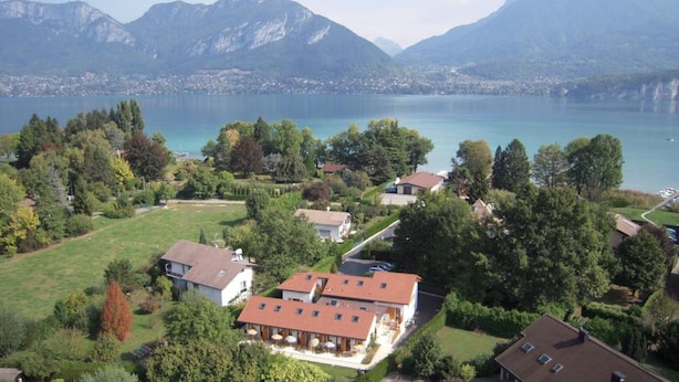 Ein Wohngebiet mit Häusern, einem See und Bergen im Hintergrund.