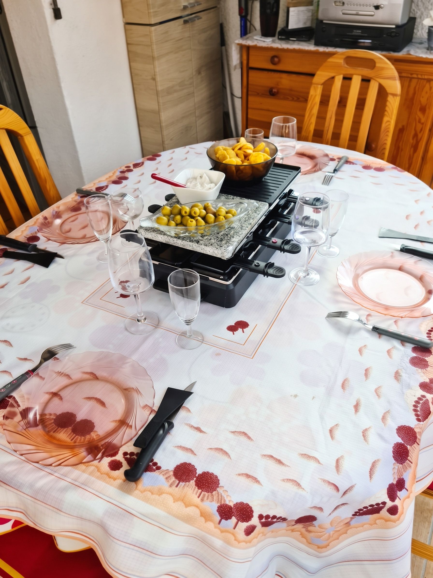 A dining table set with a fruit bowl, glasses, and cutlery.