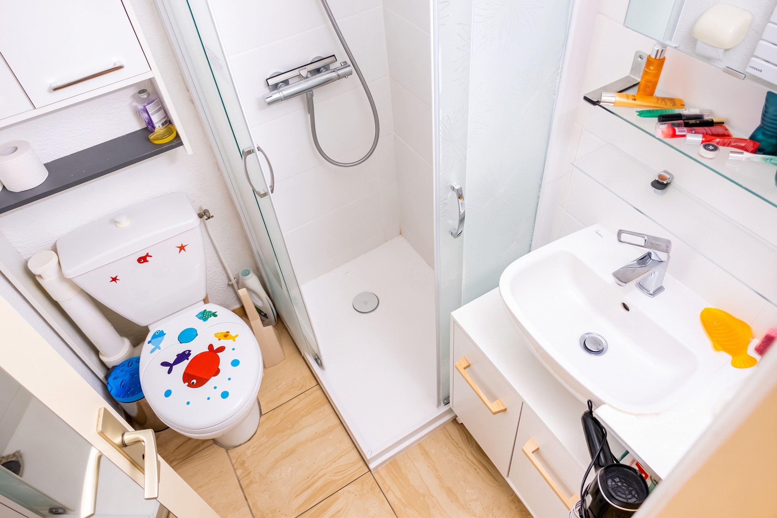 Ein kleines Badezimmer mit Toilette, Dusche und Waschbecken.