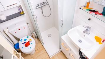 Ein kleines Badezimmer mit Toilette, Dusche und Waschbecken.