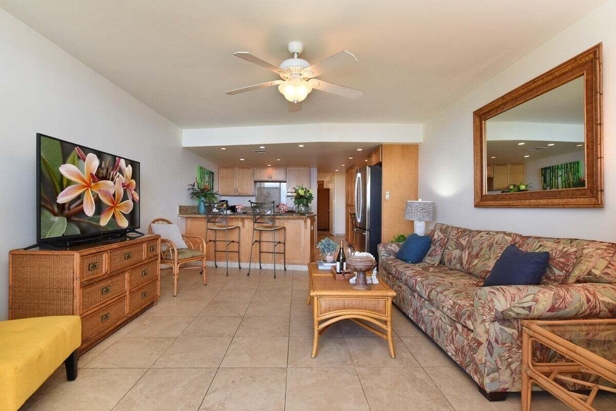 Ein Wohnzimmer mit Fernseher, Sofa und Essbereich.