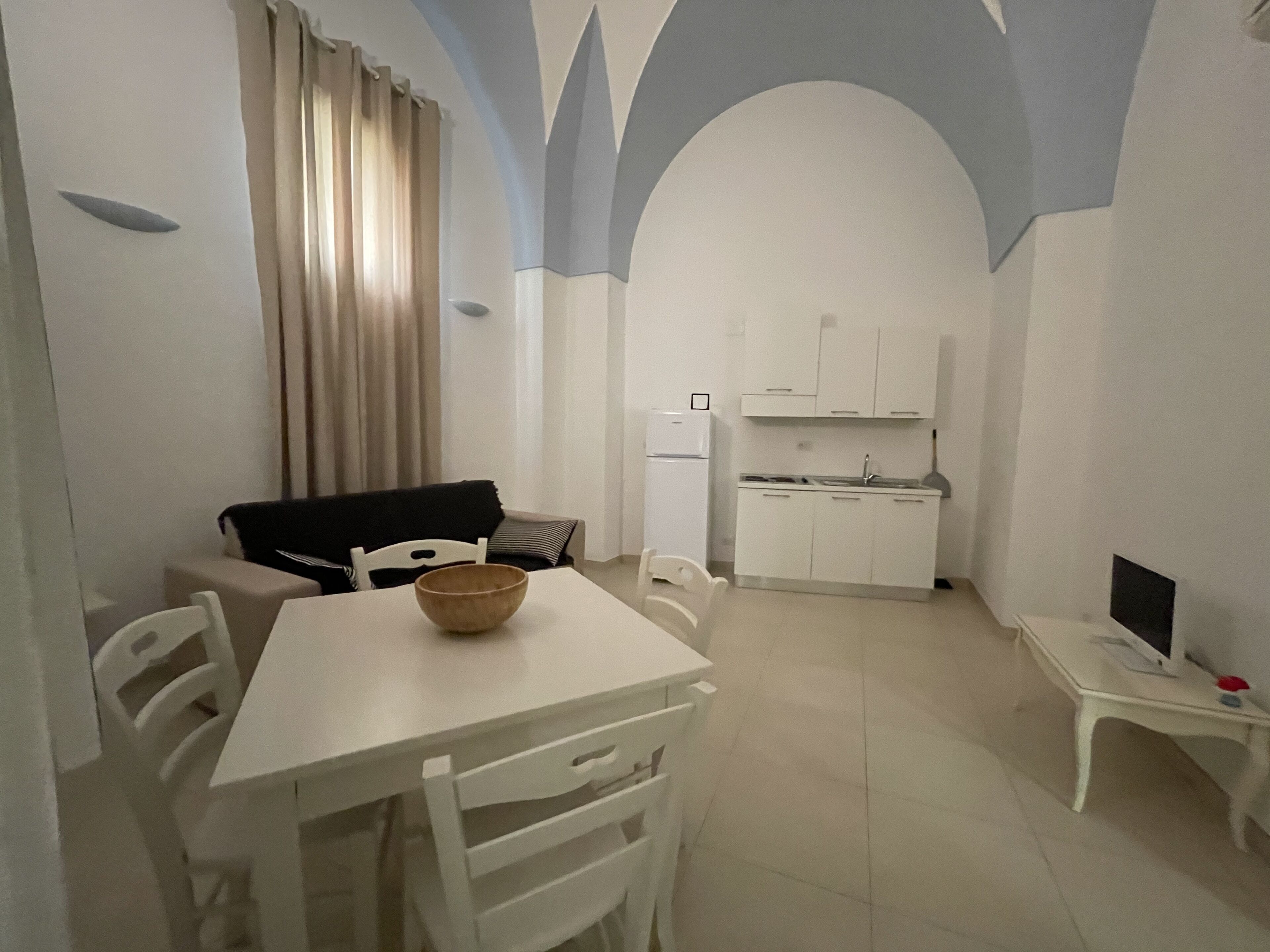 Un espace de vie compact comprenant un coin repas, une kitchenette et un canapé.