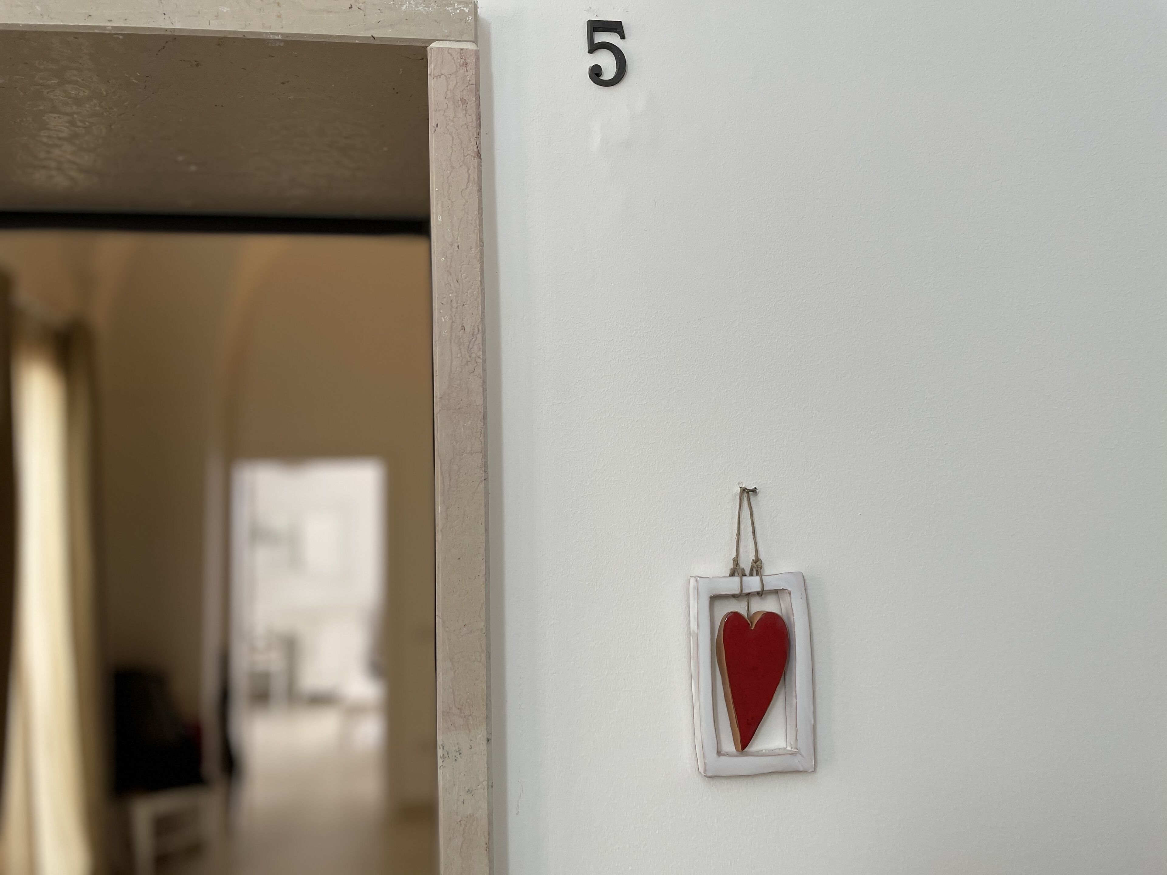 A white wall with a number '5' and a heart-shaped decoration.