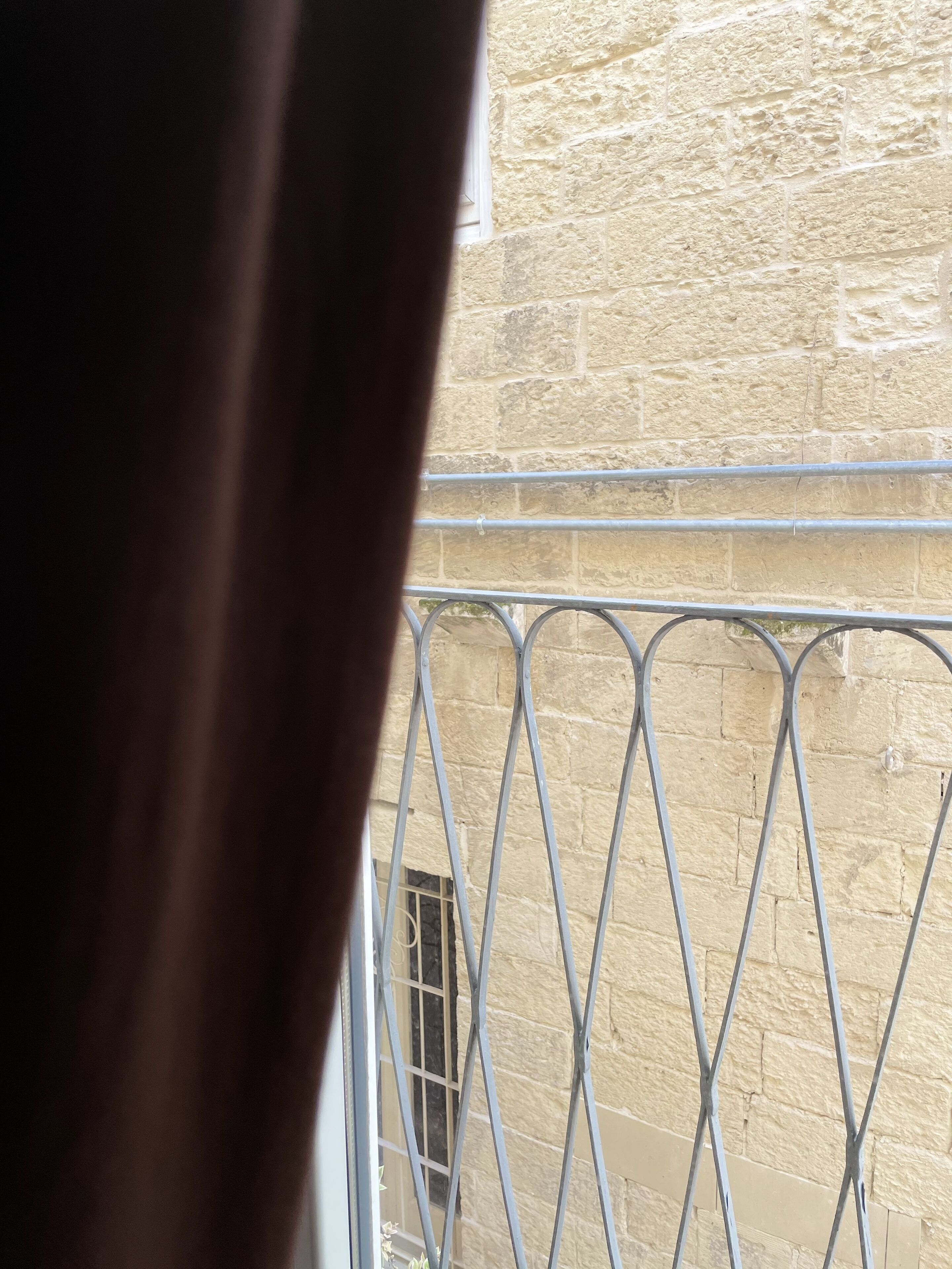 A view of a stone wall with a metal railing.