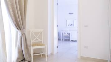 Una habitación blanca con una silla y una mesa.