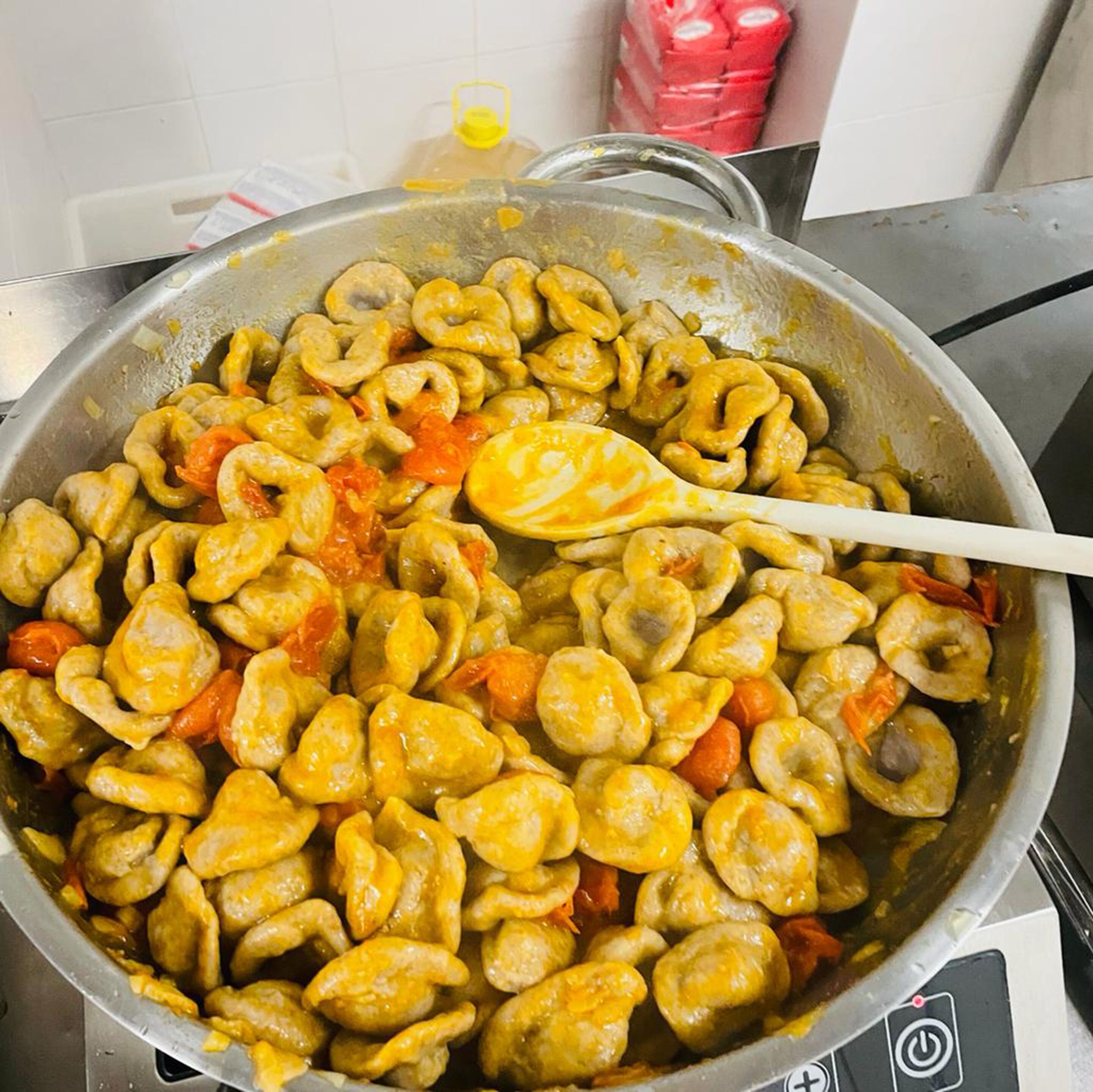 A pan with cooked pasta and vegetables.