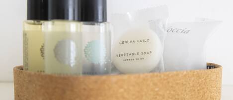 A basket containing various toiletries including a bottle of vegetable soap and a toiletry bag.