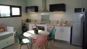 A compact kitchen with a dining area, a washing machine, a microwave, and a refrigerator. - Cottage between sea and mountains with private pool (and heated) - View Pyrenees (Laà-Mondrans)