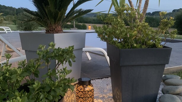 A rooftop garden with potted plants, a decorative lantern, and a stone wall. - Cottage between sea and mountains with private pool (and heated) - View Pyrenees (Laà-Mondrans)