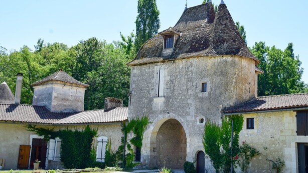 Un bâtiment en pierre doté d’un toit conique, d’une entrée en arc de cercle et d’une petite fenêtre.