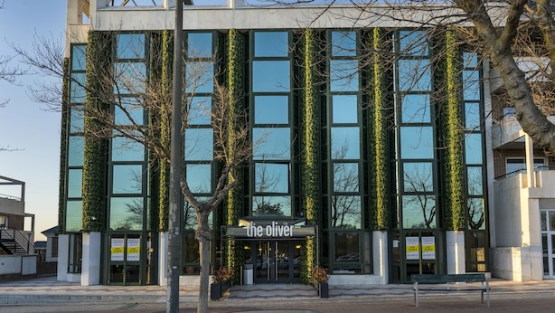 A modern building with a sign reading "The Oliver" at the entrance.