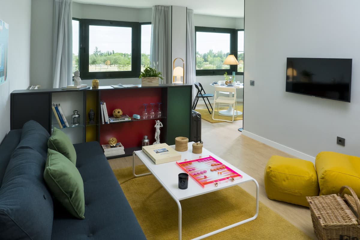 Ein modernes Wohnzimmer mit einer Couch, einem Couchtisch und einem an der Wand befestigten Fernseher.
