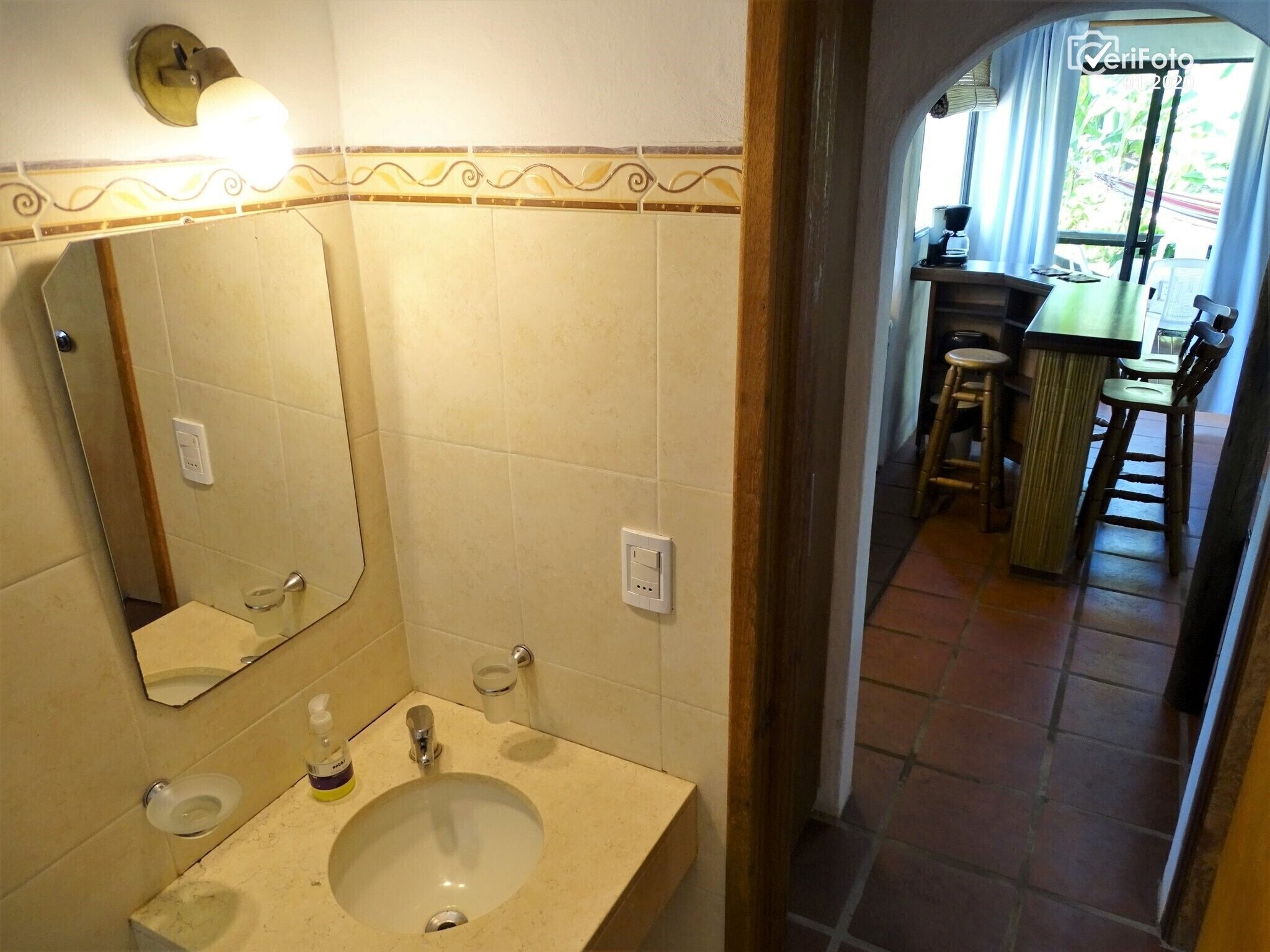 Un baño con lavamanos, espejo e iluminación.