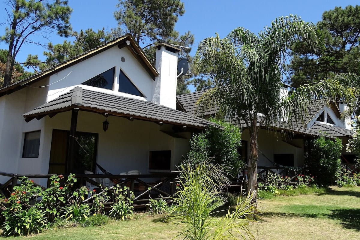 A white building with a tiled roof and a small porch.