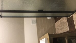 Ein Badezimmer mit weißem Waschbecken, einem Spiegel und einem Handtuchhalter.