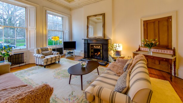 Un salón amplio con chimenea, ventanas grandes y una zona de estar acogedora.