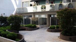 A modern building with a courtyard featuring planters and a concrete pathway. - Cozy studio in the heart of Recoleta. VLPlaza (CABA)