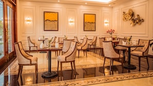 Un comedor espacioso con varias mesas y sillas, arte de pared elegante e iluminación ambiental.