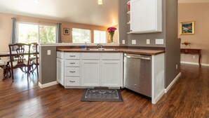 A kitchen with white cabinets, a stainless steel dishwasher, and a wooden countertop. - Furnished 30+ day rental close to Old Mill! Dog Friendly! (Bend)