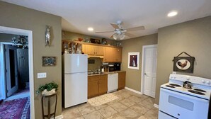 A kitchen with a refrigerator, stove, microwave, and wooden cabinets.