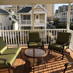 A balcony with wicker chairs and a glass table, overlooking a residential area with multi-story buildings. - Ocean Oasis - Beachside Escape w/ Balcony, Parking & Walk to Boardwalk (Atlantic City)