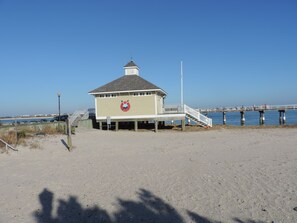 A beachside lifeguard station with a lifeguard tower, a pier extending into the water, and a clear blue sky. - Ocean Oasis - Beachside Escape w/ Balcony, Parking & Walk to Boardwalk (Atlantic City)