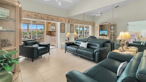 A spacious living area with leather sofas, a flat-screen TV, and a balcony with a view. - Resort Living @ Its Finest!  Spacious 2 Bed 2 Bath Condo! (Naples)