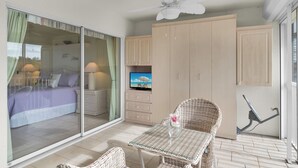 A bedroom with a sliding glass door, a bed, a television, and a ceiling fan. - Resort Living @ Its Finest!  Spacious 2 Bed 2 Bath Condo! (Naples)