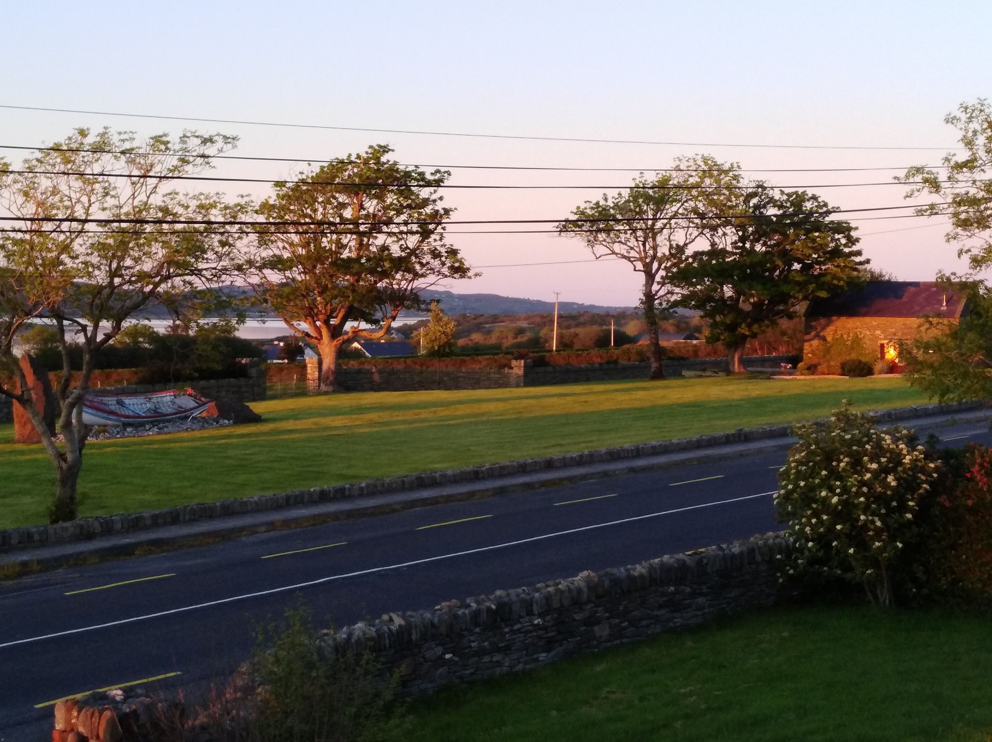 A rural road with stone walls and trees.