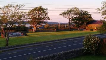 A rural road with stone walls and trees.