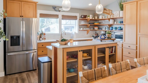 A modern kitchen with wooden cabinets, stainless steel appliances, and a central island with seating. - Two King Suites, Ocean Views & Upscale Touches in Downtown Manzanita (Manzanita)