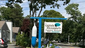 Wegwijzer voor Captain Alexander's Summer Rentals, met een blauwe raket en hortensia’s.