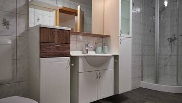 Family Apartment | Bathroom | Shower, hair dryer, slippers, towels